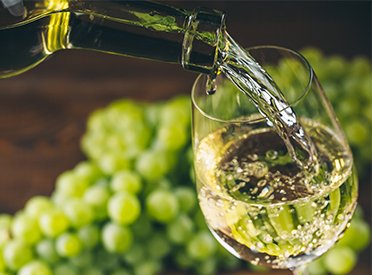 Weinglas in das Weißwein gegossen wird